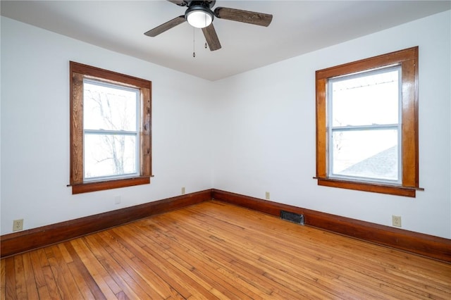 spare room featuring visible vents, ceiling fan, light wood-style flooring, and baseboards