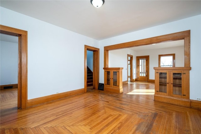 unfurnished room featuring stairs, visible vents, and baseboards