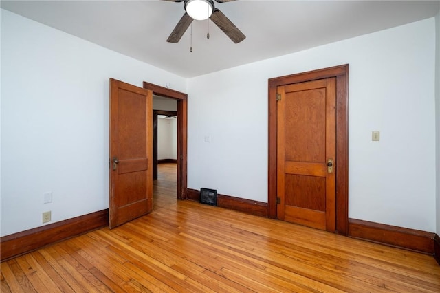 unfurnished room with light wood-style floors, ceiling fan, and baseboards