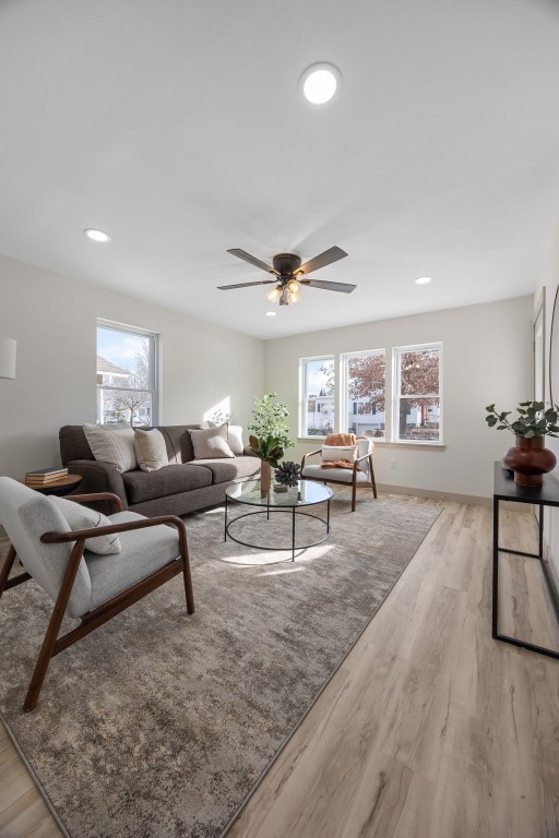 living room with light wood-style floors, ceiling fan, and recessed lighting