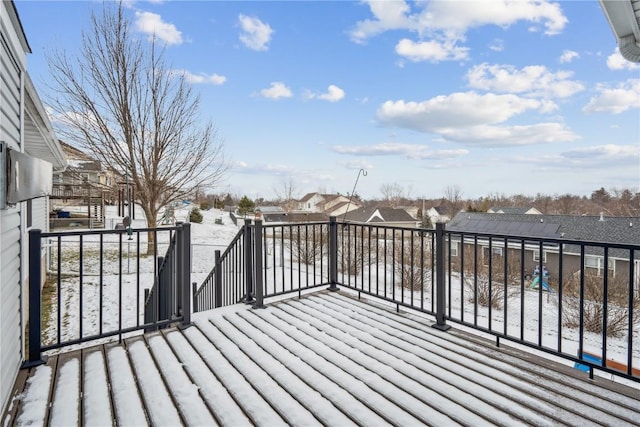 snow covered deck featuring a residential view