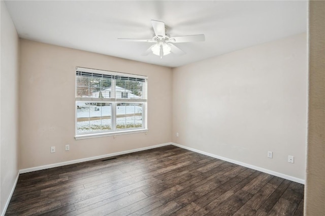 unfurnished room with ceiling fan, baseboards, and dark wood finished floors