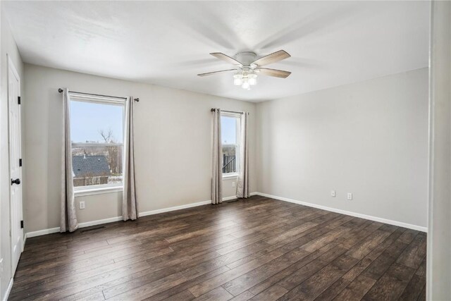 unfurnished room with baseboards and dark wood finished floors