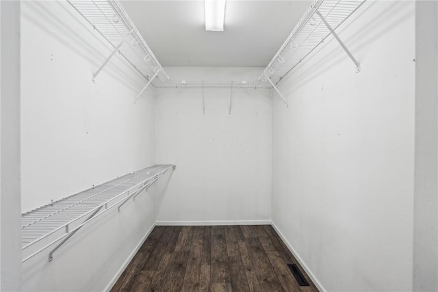 walk in closet with dark wood-style flooring and visible vents