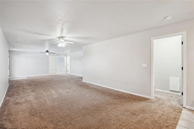 unfurnished room featuring baseboards, a ceiling fan, and light colored carpet