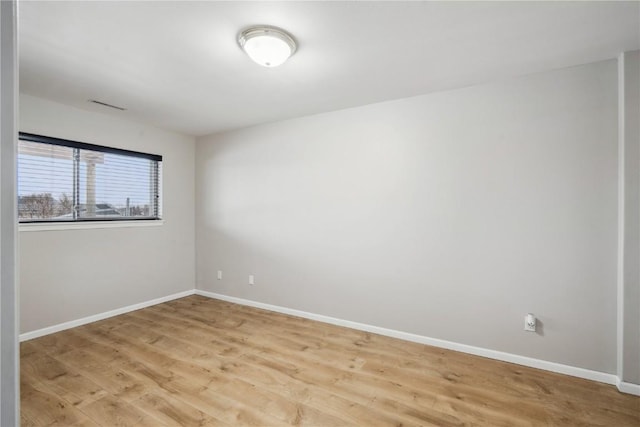 unfurnished room with light wood-style flooring and baseboards