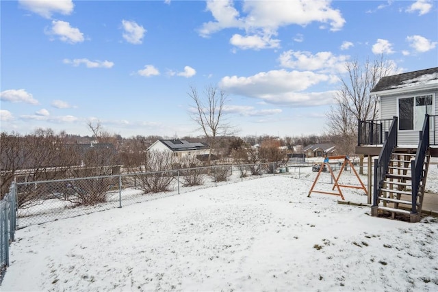 snowy yard with fence and a playground