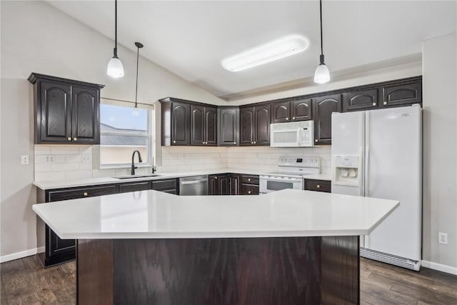 kitchen featuring a center island, light countertops, hanging light fixtures, a sink, and white appliances