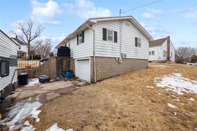 view of side of home featuring a garage and aphalt driveway