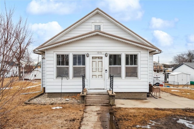 bungalow featuring entry steps, a patio, and an outbuilding