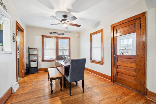 dining space with light wood-type flooring, baseboards, visible vents, and ceiling fan