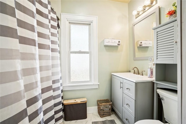 bathroom featuring toilet, marble finish floor, baseboards, and vanity