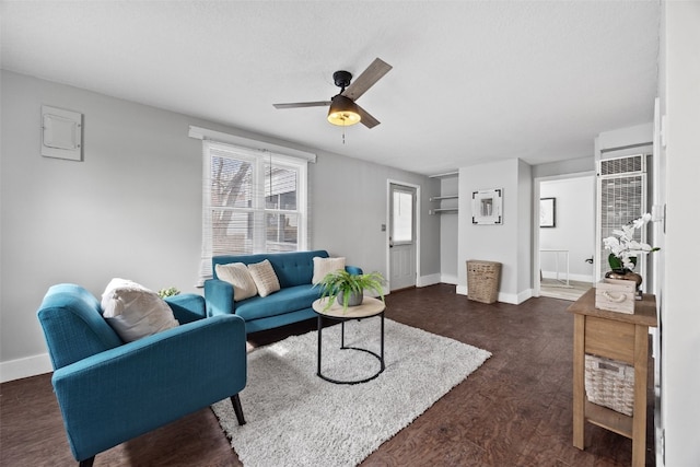 living room with ceiling fan, dark wood-style floors, and baseboards