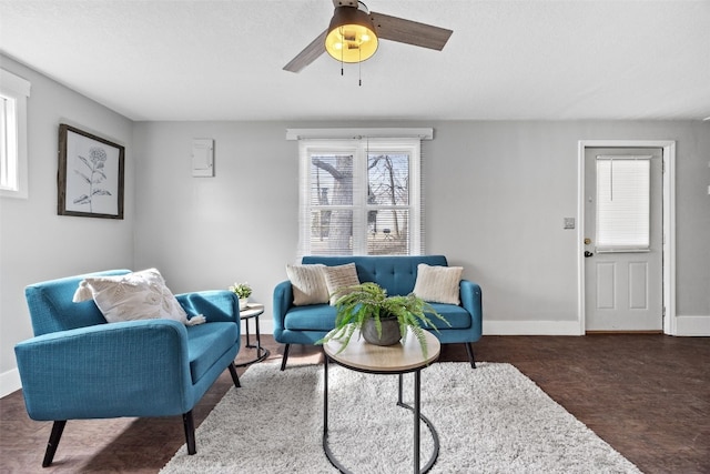 living room featuring ceiling fan, dark wood finished floors, and baseboards