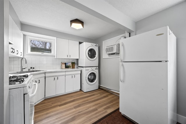 kitchen featuring light countertops, white appliances, white cabinets, and stacked washer / drying machine