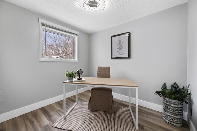 office area with dark wood-style floors, a textured ceiling, and baseboards