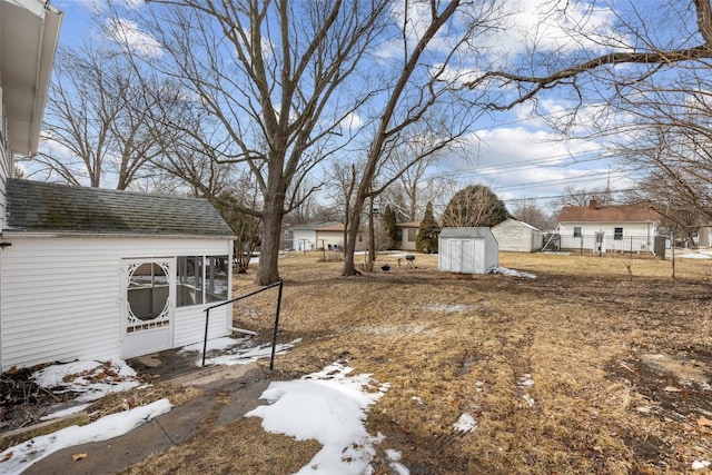 yard layered in snow with an outdoor structure and a storage shed