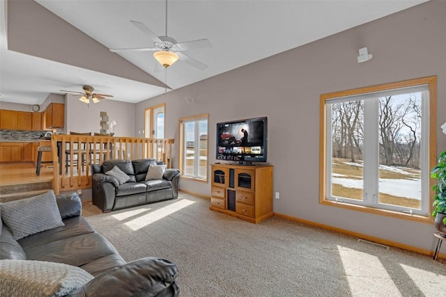 living room featuring light carpet, baseboards, visible vents, ceiling fan, and vaulted ceiling