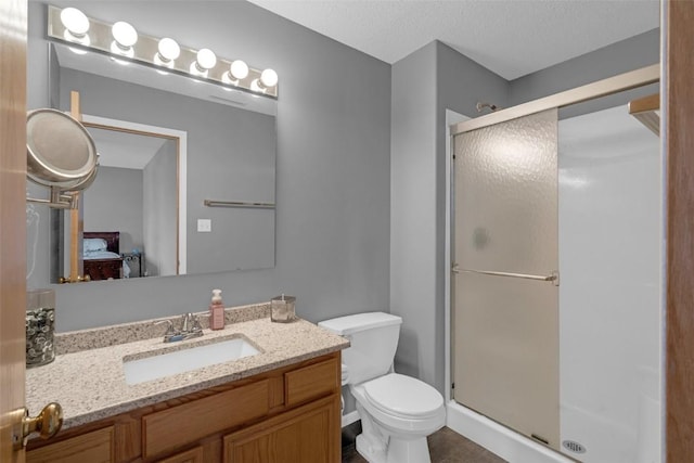 full bath with ensuite bathroom, a textured ceiling, toilet, vanity, and a stall shower