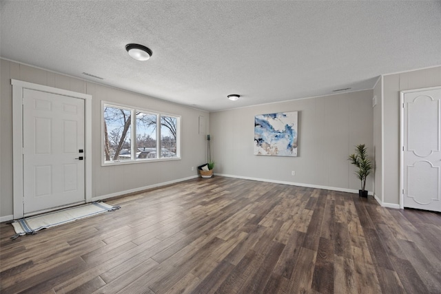 entrance foyer with dark wood-style floors, baseboards, and a textured ceiling