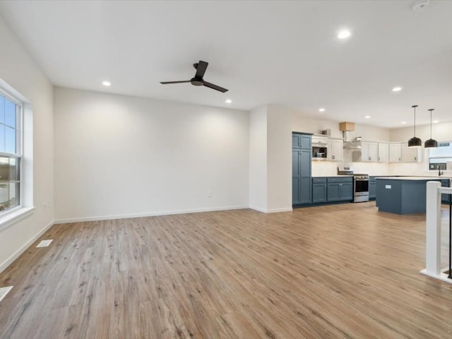 unfurnished living room featuring light wood-style floors, baseboards, and recessed lighting