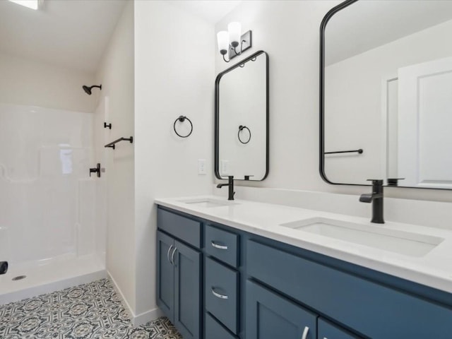 bathroom with a stall shower, a sink, and double vanity