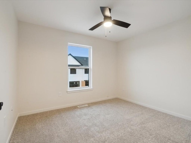 empty room featuring carpet, visible vents, baseboards, and a ceiling fan