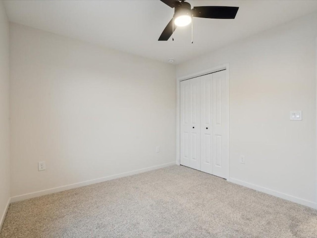 unfurnished bedroom with carpet floors, a closet, ceiling fan, and baseboards