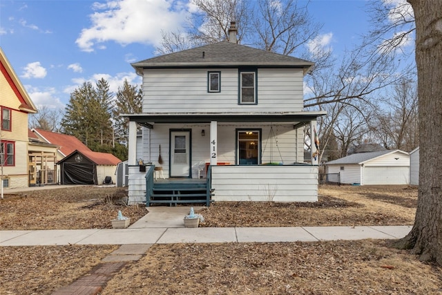 view of front of house featuring a garage, covered porch, and an outdoor structure