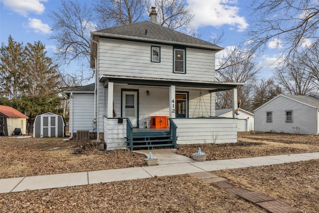 view of front of home featuring a storage unit, a porch, an outdoor structure, and a shingled roof