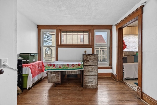 bedroom featuring a textured ceiling, hardwood / wood-style floors, and baseboards