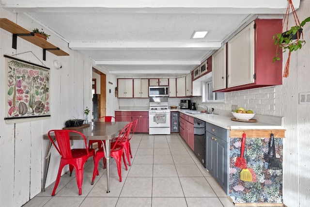 kitchen featuring black dishwasher, light countertops, stainless steel microwave, white range with gas cooktop, and beamed ceiling