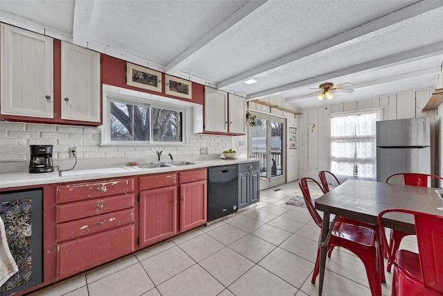 kitchen featuring wine cooler, light countertops, freestanding refrigerator, a sink, and dishwasher