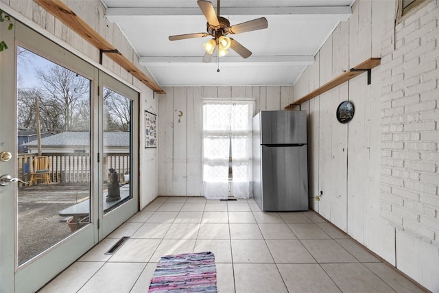 unfurnished sunroom featuring ceiling fan, visible vents, and beam ceiling