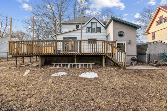 rear view of property featuring fence and a deck