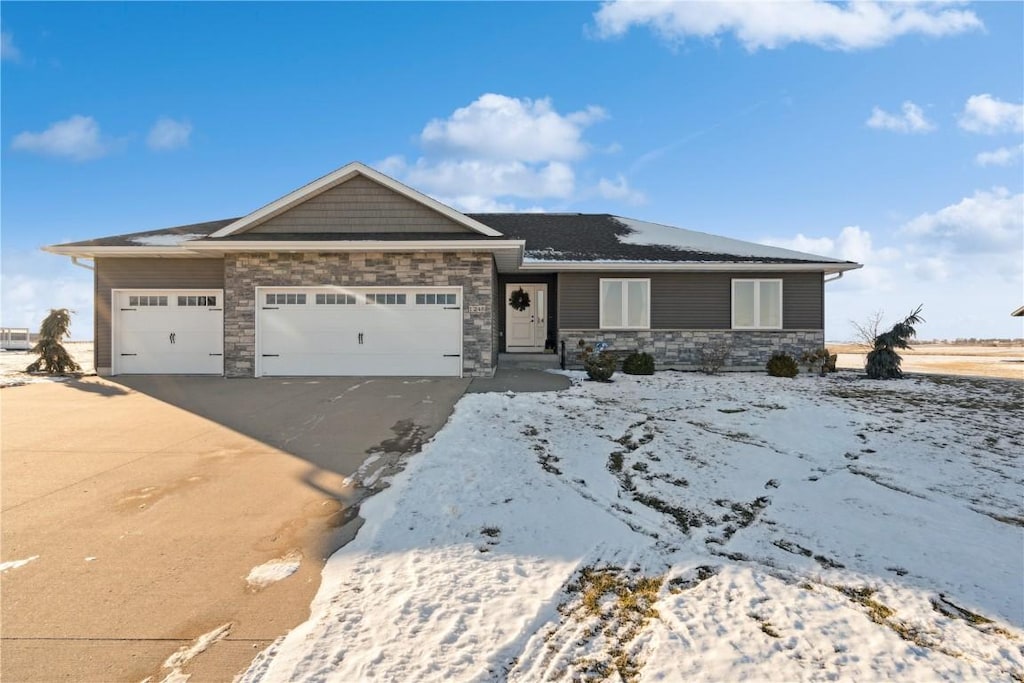 view of front of home featuring stone siding, driveway, and an attached garage