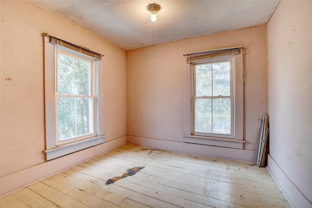 spare room with hardwood / wood-style flooring and a healthy amount of sunlight