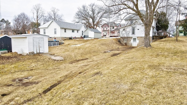 view of yard featuring a residential view, an outdoor structure, and a shed