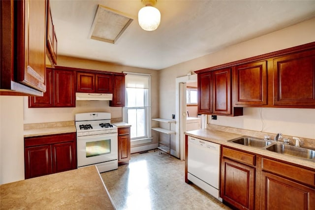 kitchen with reddish brown cabinets, white appliances, a sink, and under cabinet range hood