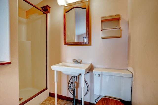 bathroom featuring toilet and a stall shower