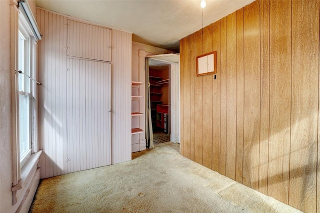 hall with wooden walls and carpet flooring