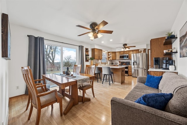 dining room featuring baseboards, light wood finished floors, a ceiling fan, and recessed lighting