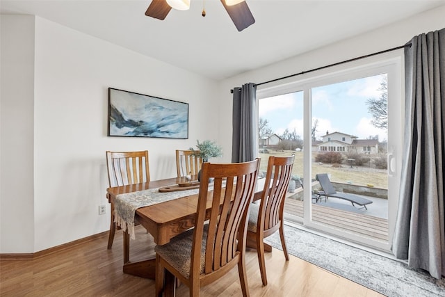 dining area with light wood-style floors, baseboards, and a ceiling fan