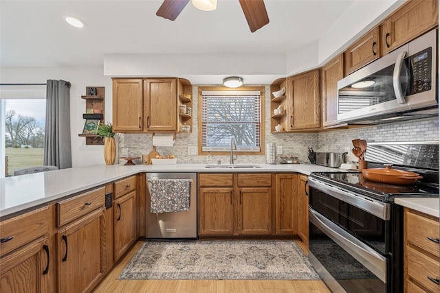 kitchen featuring open shelves, a wealth of natural light, stainless steel appliances, and a sink