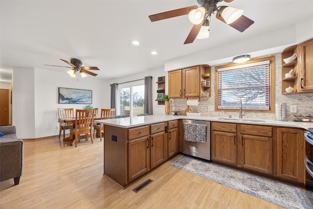 kitchen featuring open shelves, stainless steel appliances, visible vents, a sink, and a peninsula