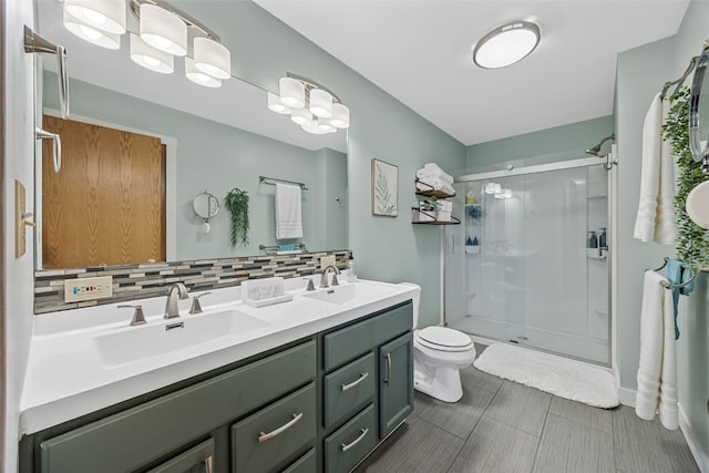 bathroom featuring toilet, a shower stall, backsplash, and a sink