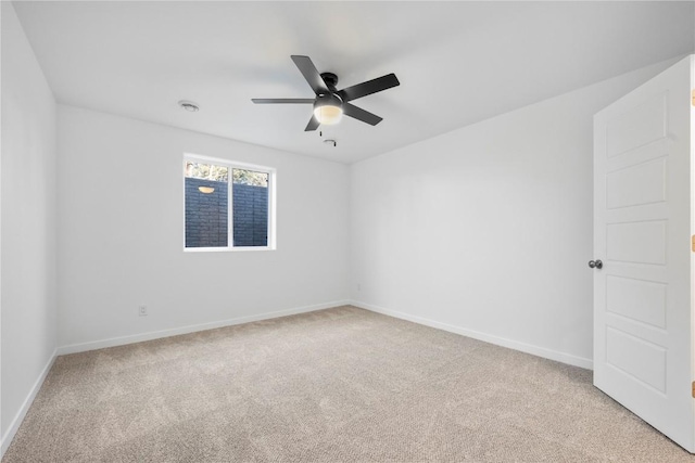 unfurnished room with baseboards, a ceiling fan, and light colored carpet