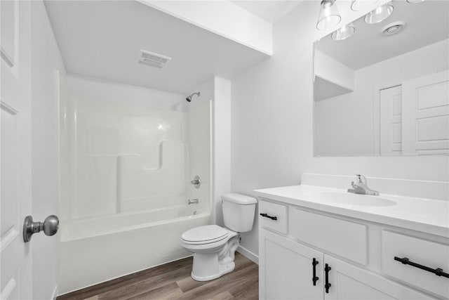 bathroom featuring shower / washtub combination, visible vents, toilet, vanity, and wood finished floors