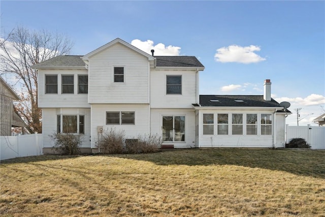 back of property featuring a lawn, fence, and a sunroom