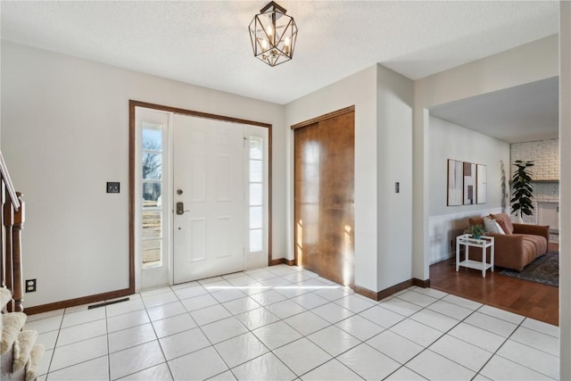 entrance foyer featuring light tile patterned flooring, a wealth of natural light, and a textured ceiling